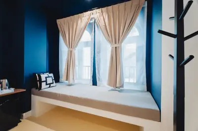 a window seat in a room with blue walls at Xinlor House - Phuket Old Town in Phuket Town
