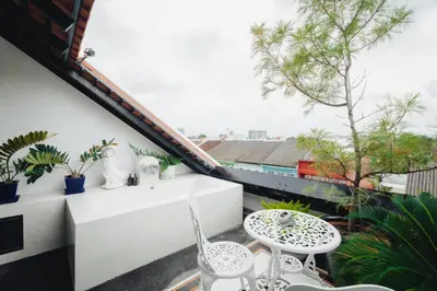a balcony with a table and chairs and plants at Xinlor House - Phuket Old Town in Phuket Town