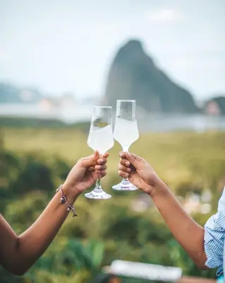 two people holding up glasses of white wine at Sametnangshe Boutique in Phangnga