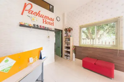 a waiting room at a pajamas hotel with a red chair at Pachumas Hotel in Karon Beach