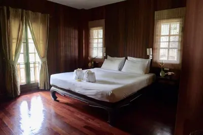 a bedroom with a large white bed with windows at Symphony Villa in Nai Harn Beach