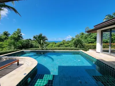 a swimming pool with a view of the ocean at Baan Phukhao in Klong Muang Beach