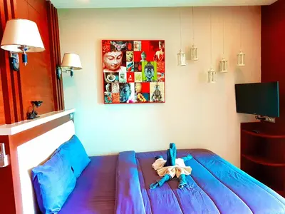 a bedroom with a blue bed with a toy on it at Sea & Sky Karon Beach by PHR in Karon Beach
