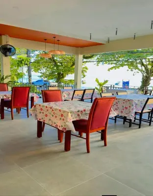 a table and chairs sitting on a patio with a table at Mukrada House Boutique Hometel Krabi in Klong Muang Beach