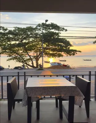 a table and chairs on a balcony with a view of the ocean at Mukrada House Boutique Hometel Krabi in Klong Muang Beach