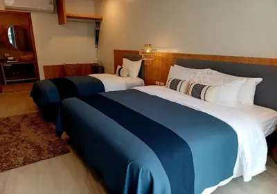 a hotel room with two beds with blue and white sheets at Mukrada House Boutique Hometel Krabi in Klong Muang Beach