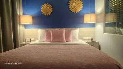 a bedroom with a bed with pink pillows and two lamps at Mukrada House Boutique Hometel Krabi in Klong Muang Beach