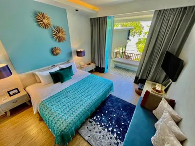 a bedroom with a bed with a blue wall at Mukrada House Boutique Hometel Krabi in Klong Muang Beach