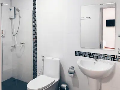 a white bathroom with a toilet and a sink at Ban Don Holidayhome in Thalang