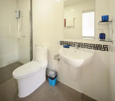 a white bathroom with a toilet and a sink at Ban Don Holidayhome in Thalang