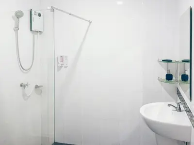 a white bathroom with a shower and a sink at Ban Don Holidayhome in Thalang