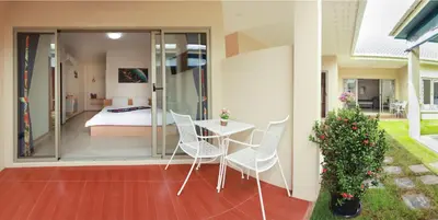 a room with a bed and a table and chairs at Ban Don Holidayhome in Thalang