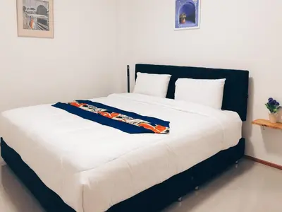a bedroom with a large white bed with white pillows at Ban Don Holidayhome in Thalang