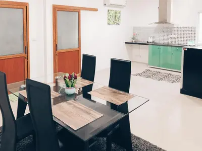 a dining room with a glass table and chairs at Ban Don Holidayhome in Thalang