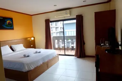 a bedroom with a bed and a large window at Baantonkhaokata Hotel in Kata Beach