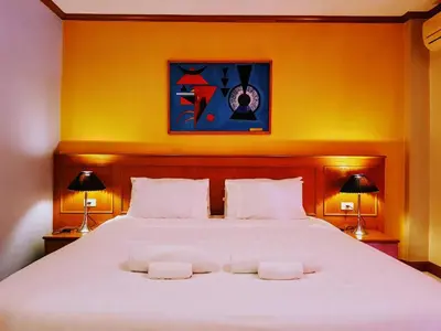 a bedroom with a large bed with two towels on it at Baantonkhaokata Hotel in Kata Beach