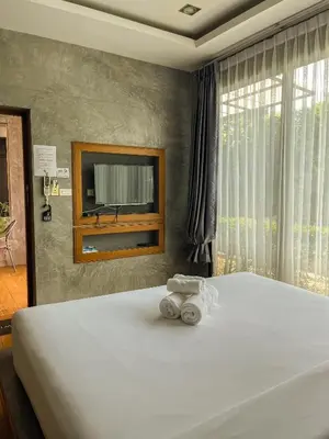a bedroom with a large bed with a tv on the wall at BaanMee Phuket near Chalong Pier in Chalong