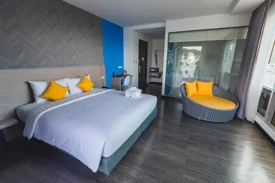 a bedroom with a large bed and a chair at Wake Up Aonang Hotel in Ao Nang Beach