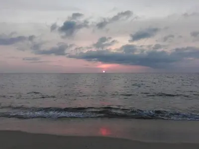 a sunset over the ocean on a beach at Maikhao Beach Guest House in Mai Khao Beach
