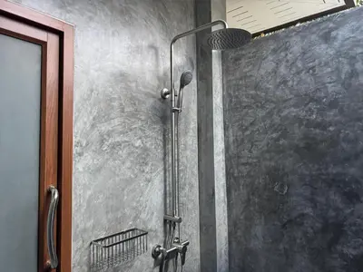 a shower with a shower head in a bathroom at Maikhao Beach Guest House in Mai Khao Beach