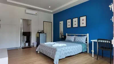 a blue bedroom with a bed and a blue wall at Vii House Rawai Phuket in Rawai Beach