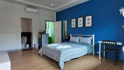 a blue bedroom with a bed and a blue wall at Vii House Rawai Phuket in Rawai Beach