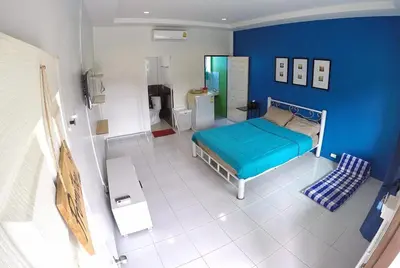 a bedroom with a bed and a blue wall at Vii House Rawai Phuket in Rawai Beach