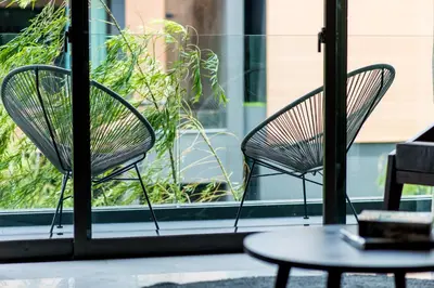 two chairs and a table in front of a window at Glam Habitat - SHA Extra Plus in Kamala Beach