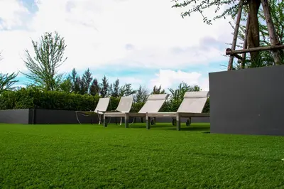 a row of chairs sitting on a grass field at Glam Habitat - SHA Extra Plus in Kamala Beach