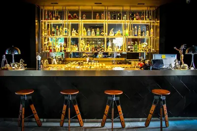 a bar with three stools in front of a counter at Glam Habitat - SHA Extra Plus in Kamala Beach