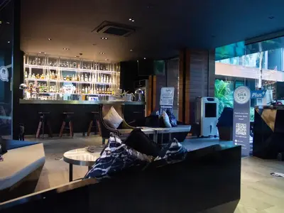 a room with a bar with a couch and a table at Glam Habitat - SHA Extra Plus in Kamala Beach