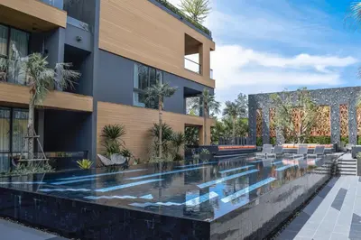 an external view of a building with a swimming pool at Glam Habitat - SHA Extra Plus in Kamala Beach