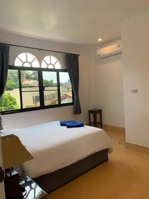 a bedroom with a bed and a large window at Fantasy Hill Bungalow in Kata Beach