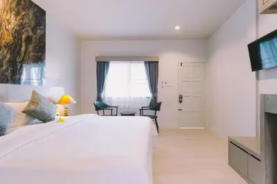 a bedroom with a large white bed and a desk at Fantasy Hill Bungalow in Kata Beach