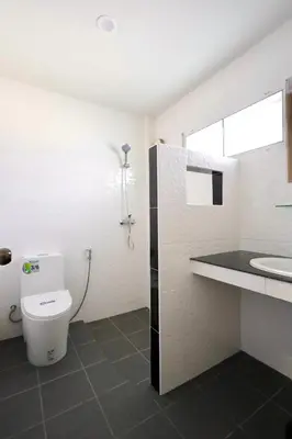 a white bathroom with a toilet and a sink at Fantasy Hill Bungalow in Kata Beach