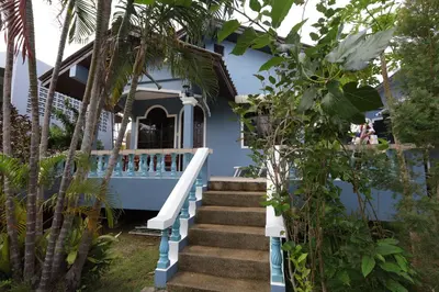 a blue house with stairs leading up to it at Fantasy Hill Bungalow in Kata Beach