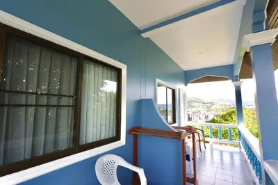 a blue room with a balcony with a window at Fantasy Hill Bungalow in Kata Beach