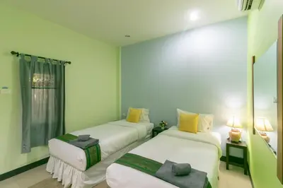 a room with two beds and a window at Chaiyo Resort in Phuket Town