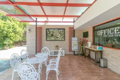 a patio with white chairs and tables and a counter at Chaiyo Resort in Phuket Town