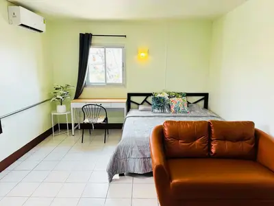 a bedroom with a bed and a couch at K.L.Apartment in Chalong