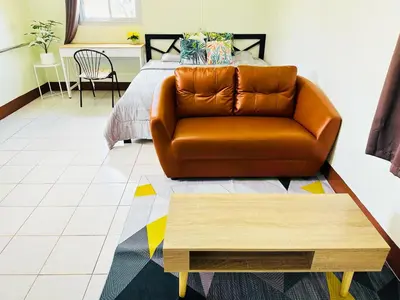 a living room with a couch and a bed at K.L.Apartment in Chalong