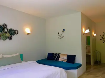 a bedroom with a bed and a blue bench at Sense of Yanui in Nai Harn Beach