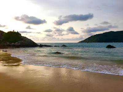 a beach with the ocean and rocks in the water at Sense of Yanui in Nai Harn Beach
