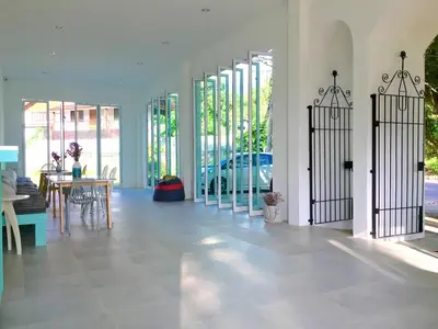 a room with glass doors and a table and chairs at Sense of Yanui in Nai Harn Beach