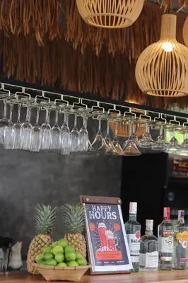 a book sitting on top of a bar with pineapple and glasses at Panphuree Residence in Nai Yang Beach