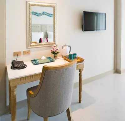 a desk in a room with a phone and a mirror at Panphuree Residence in Nai Yang Beach
