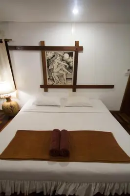 a bed with two pairs of slippers on it at Tropical Garden Bungalow in Phi Phi Don