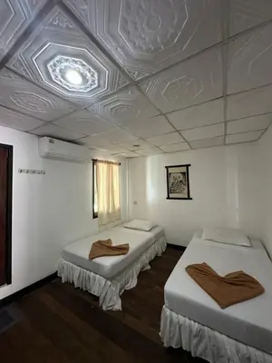 two beds in a room with a coffered ceiling at Tropical Garden Bungalow in Phi Phi Don