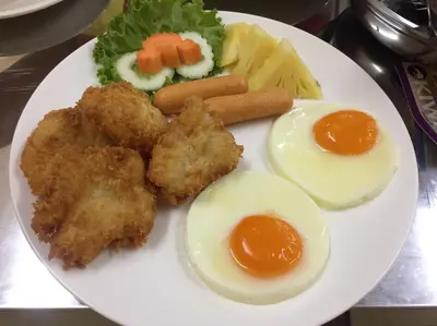 a plate of food with fried chicken and eggs and vegetables at Phuket Chinoinn-SHAPlus Certified in Phuket Town