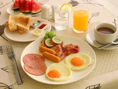 a table with two plates of breakfast food and a cup of coffee at Phuket Chinoinn-SHAPlus Certified in Phuket Town